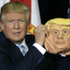 A hideous rubber mask holds up a Halloween costume. Photo via AP